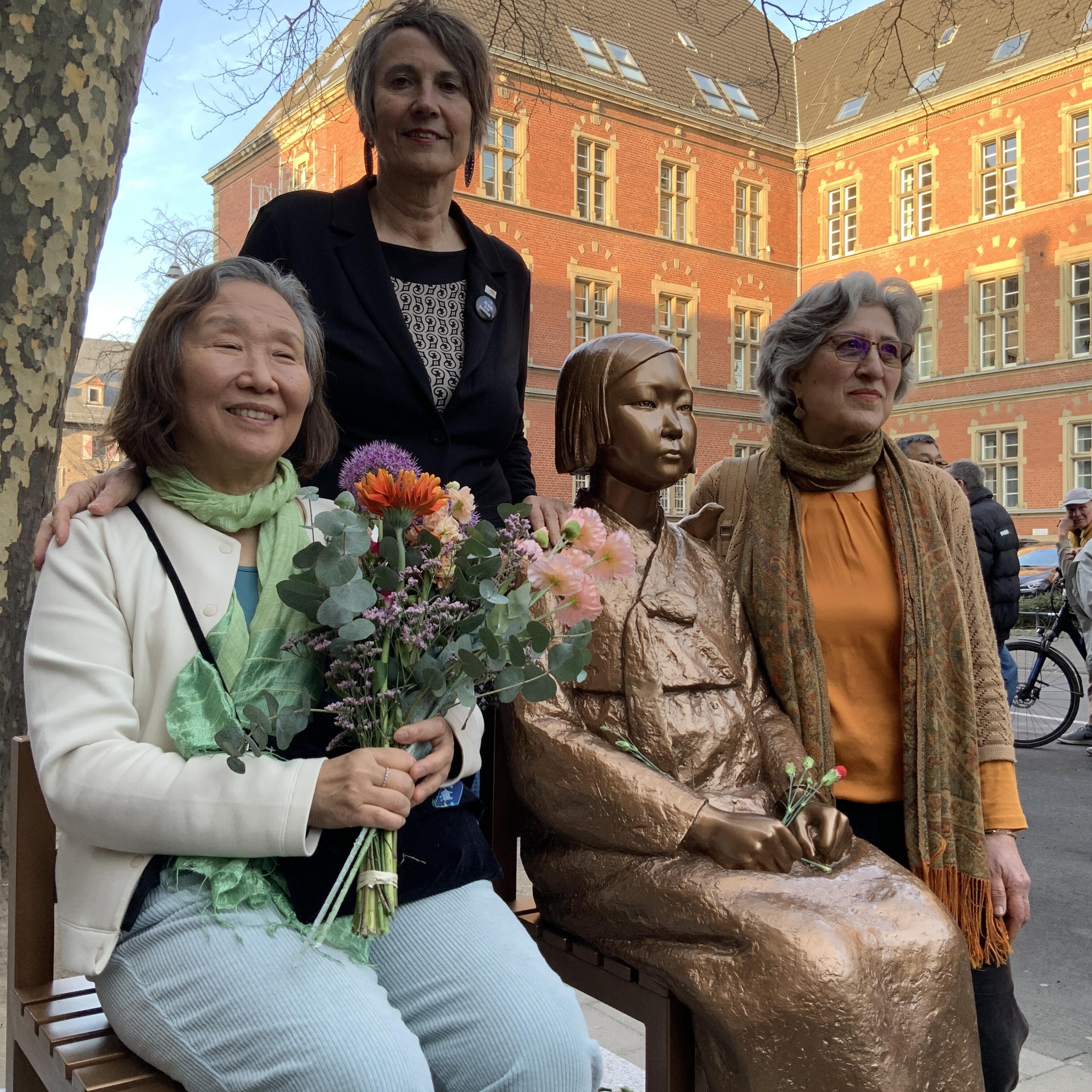 Nataly Jung-Hwa-Han vom Koreaverband, Monika Hauser von Medica Mondiale und Behshid Najafi Agisra e.V. Köln posieren mit der "Friedensstatue".
