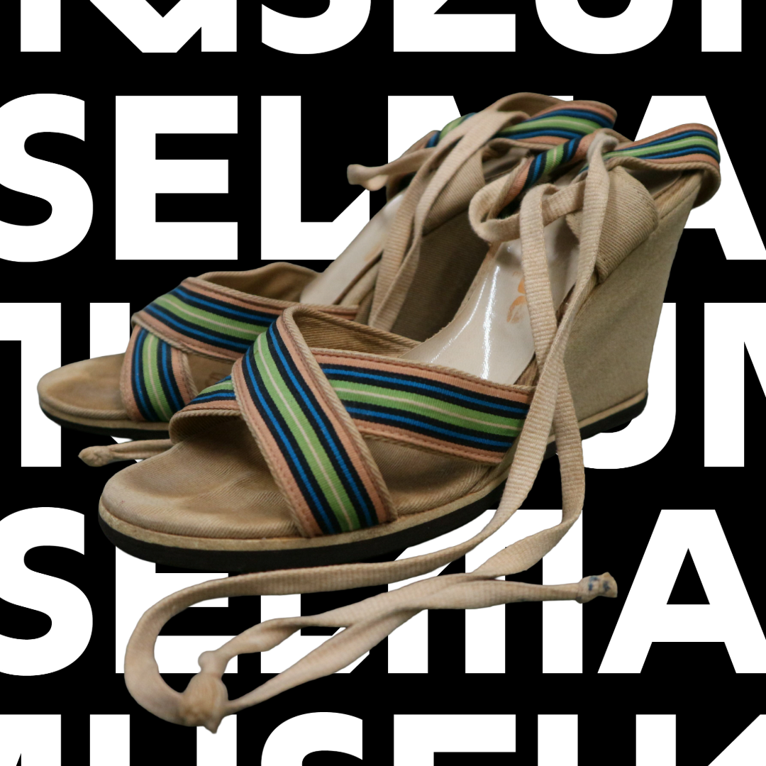 Ein paar bunter Sandalen ist auf einem schwarz-weißen Hintergrund zu sehen.