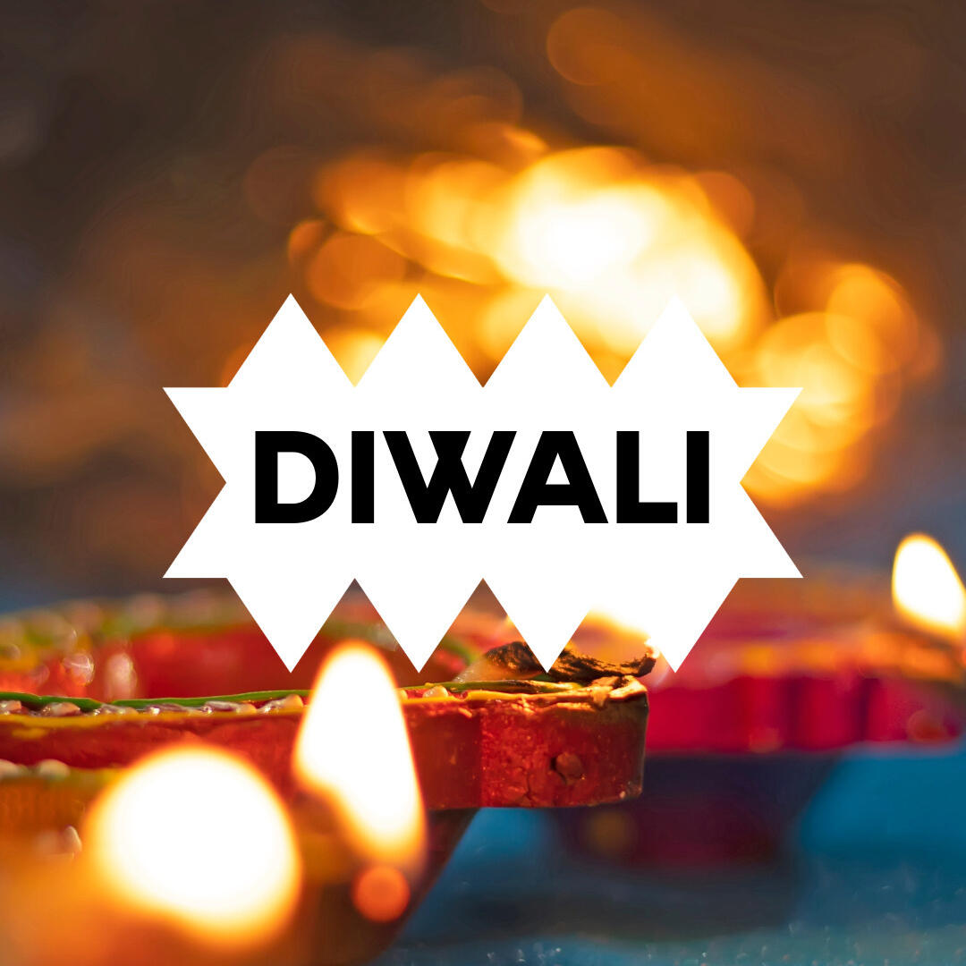 "DIWALI" steht in Großbuchstaben im Vordergrund, im Hintergrund brennende Kerzen.