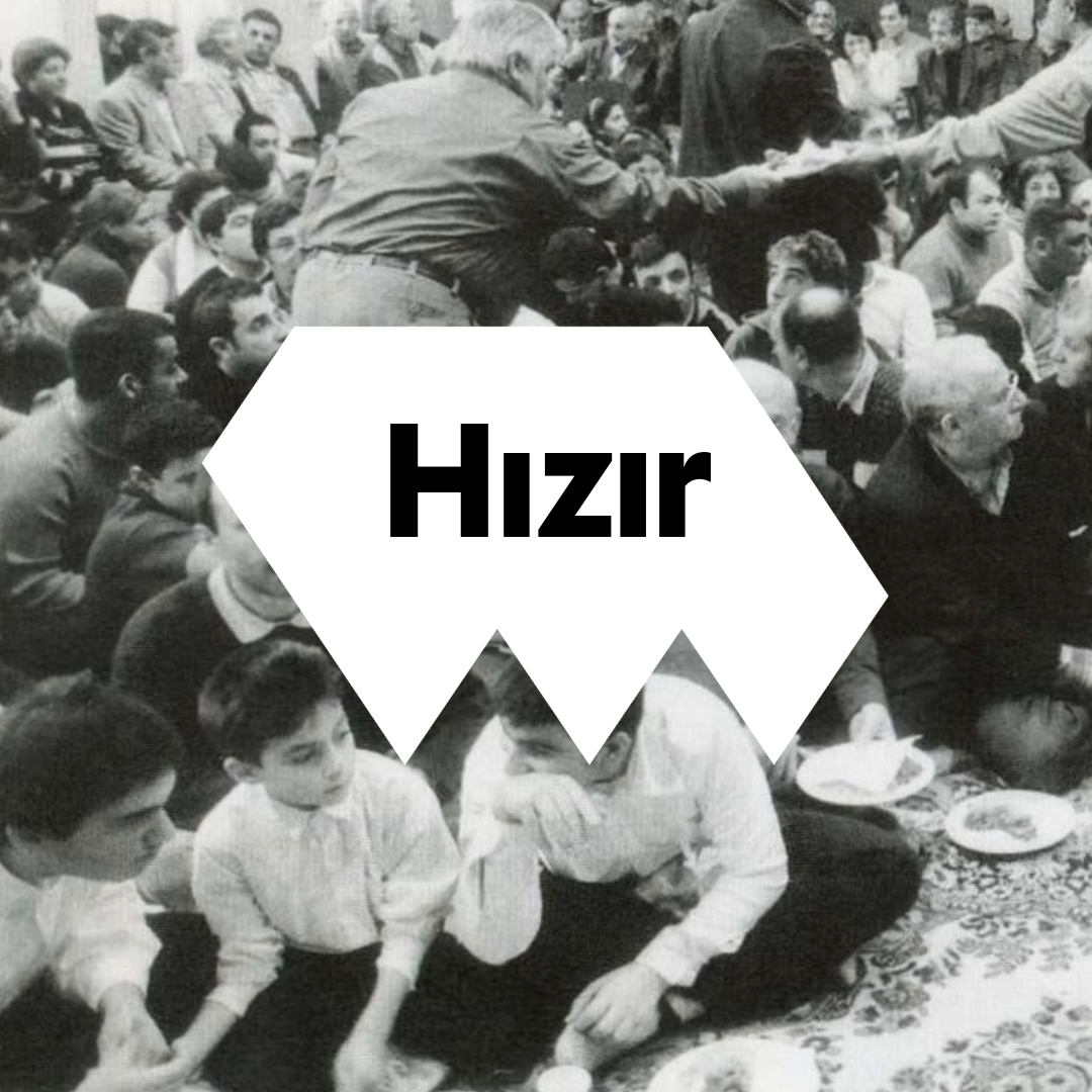 Schwarz-weiß Foto aus einem alevitischen Kulturzentrum, auf dem viele Menschen gemeinsam essen.