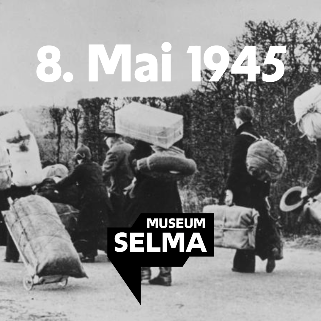 In the black and white photography there are a lot of people. These people are walking away from the photographer. They are wearing winter clothes and carrying big suitcases and bags.